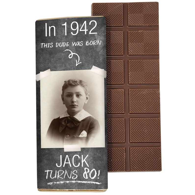 Może przedstawiać: Tabliczka czekolady z opakowaniem z tablicy szkolnej. Opakowanie zawiera zdjęcie młodego chłopca i tekst "In 1942 this dude was born" oraz "Jack turns 80!"