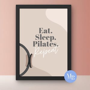 Op de afbeelding: Ingelijste kunstdruk met de woorden "Eat. Sleep. Pilates. Repeat" in een stijlvol lettertype. De print heeft een neutraal kleurenpalet met een beige achtergrond en een zwart frame. Een Pilates reformer-afbeelding staat links.