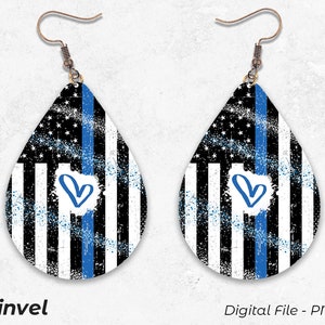 May include: A pair of teardrop-shaped earrings with a blue and white American flag design and a blue heart. The earrings have a distressed look and are made of metal.