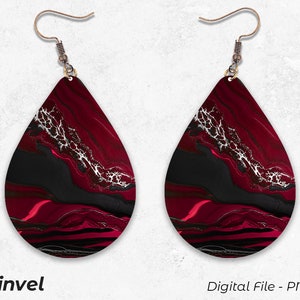 May include: A pair of teardrop-shaped earrings with a black, red, and silver abstract design. The earrings have a silver hook.