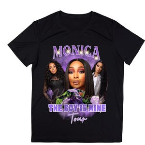 Pode incluir: Camiseta preta com um gráfico de Monica, o texto "MONICA" acima de sua imagem e o texto "THE BOY IS MINE Tour" em roxo e branco. O gráfico apresenta três mulheres. A camiseta tem gola redonda.