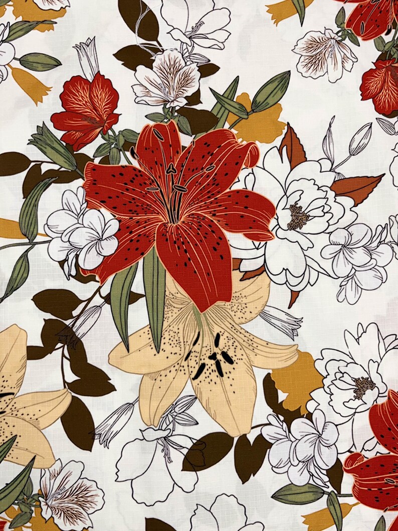 K&ouml;nnte beinhalten: Stoff mit floralem Muster, das Lilien und andere Blumen in Rot, Wei&szlig;, Gelb und Gr&uuml;n auf wei&szlig;em Hintergrund zeigt. Das Muster kombiniert detaillierte und skizzierte florale Elemente und erzeugt einen geschichteten Effekt. Geeignet f&uuml;r N&auml;h- und Bastelprojekte, mit botanischem Thema.