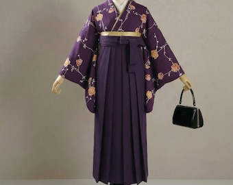 May include: A deep purple kimono featuring a pattern of orange roses on thin vines, paired with a matching pleated hakama skirt. A gold obi sash is tied at the waist, and a small black handbag with a metal frame is held to the side of the garment.