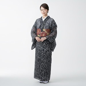 May include: A woman in a black and silver patterned kimono with a floral obi. The kimono has long sleeves and a white collar. The obi is red, black, and gold. The outfit is worn with white socks and sandals.
