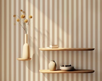 May include: Two wooden shelves with rounded edges are mounted on a wall with vertical brown and white stripes. A vase with dried flowers sits on the top shelf, and a book, a ceramic vase, and a bowl are on the bottom shelf.