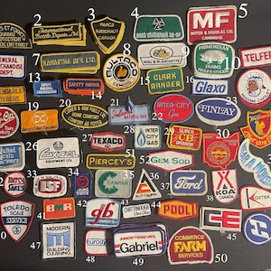 Peut inclure: Une collection de 50 patchs brodés colorés avec divers logos et textes. Les patchs sont disposés en rangées sur une surface noire. Certains patchs présentent des logos d'entreprise, tels que "Inter-City Gas", "Gem Sod", "Canpar" et "Ford". D'autres patchs présentent du texte, tel que "Safety Patrol", "Dependable Caterers" et "Modern Building Cleaning".