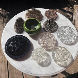 Op de afbeelding: Assortiment van bloemfroesjes voor het schikken van bloemen. De froesjes zijn gemaakt van metaal, glas en keramiek in verschillende kleuren en stijlen.