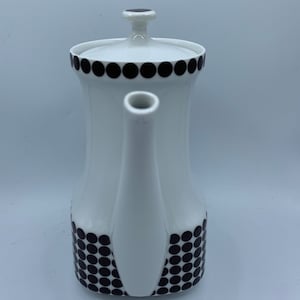 May include: White ceramic coffee pot with a black polka dot design. The pot has a lid and a spout.