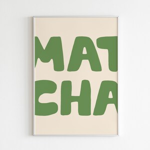 May include: A framed print with the text "MATCHA" in a bold, green font on a cream background.