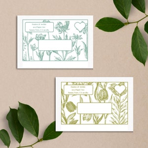 May include: Two white envelopes with green and brown floral designs. The envelopes have a heart-shaped cutout in the upper right corner. The text on the envelopes reads "Eunice & Archie, 905 Paper Ave, Sunny View, CA 90189".