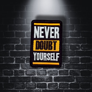 May include: Black and yellow embroidered patch with the text "Never Doubt Yourself".