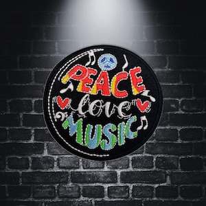 Könnte beinhalten: Ein schwarzer gestickter Aufnäher mit den Worten "Peace Love Music" in bunten Buchstaben. Ein Peace-Zeichen und Noten sind ebenfalls im Design enthalten.