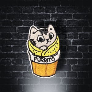 Op de afbeelding: Gestikt patch van een kat die een geel burrito-kostuum draagt met het woord "Purrito" onderaan.