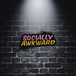 May include: A black and yellow embroidered patch with the text "SOCIALLY AWKWARD" in pink and yellow lettering.