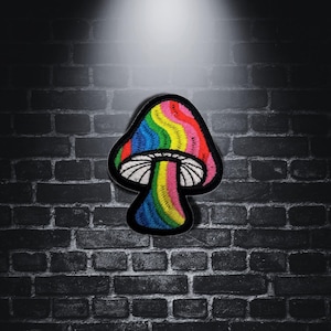 May include: A rainbow-colored mushroom patch with a white stem and a black background.