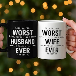 以下が含まれることがあります： 黒と白のセラミックマグカップ。白い文字で「Even on your worst days, you're still a great husband/wife ever, forget it」と書かれています。マグカップには黒いハンドルが付いています。