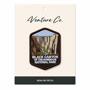 May include: Embroidered patch featuring a scenic view of Black Canyon of the Gunnison National Park. The patch is a brown, hexagonal shape with a detailed landscape design in shades of brown, green, and blue. The text "Black Canyon of the Gunnison National Park" is displayed below the image.