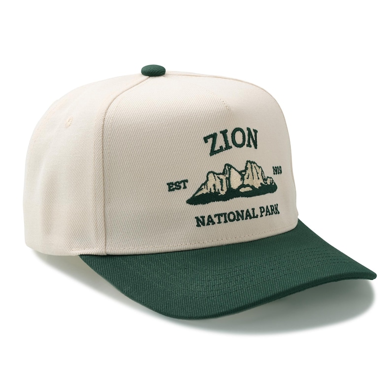 May include: A cream-colored baseball cap with a dark green brim and button. The cap features the text "ZION NATIONAL PARK" in dark green, along with a mountain graphic and the year "1919".