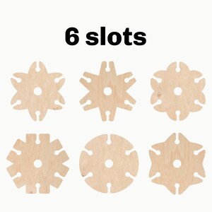 May include: Six wooden discs with different patterns, each with six slots around the edge. The text "6 slots" is printed above the discs.