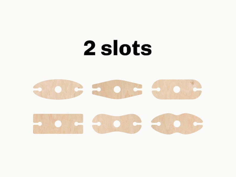 May include: Six different wooden wine bottle holders, each with two slots. The holders are in various shapes, including oval, rectangular, and a figure eight. The text "2 slots" is printed above the holders.