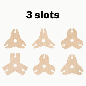 May include: Six wooden wine bottle holders, each with three slots. The holders are in the shape of a triangle with a round hole in the center. The text "3 slots" is printed above the holders.