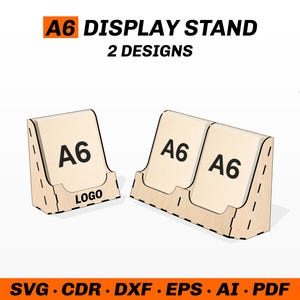 以下が含まれることがあります： 「A6」と「LOGO」の文字が入った、2つの木製A6ディスプレイスタンド。スタンドは薄茶色で、曲線的なデザインです。「A6 DISPLAY STAND 2 DESIGNS」の文字が上部に、「SVG • CDR • DXF • EPS • AI • PDF」の文字が下部にあります。