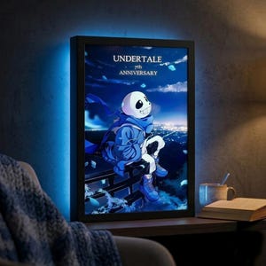 Puede incluir: Una obra de arte enmarcada con un personaje de dibujos animados azul y blanco del juego Undertale, con el texto "UNDERTALE 7th ANNIVERSARY". La imagen muestra al personaje contra un cielo nocturno con luces de la ciudad.