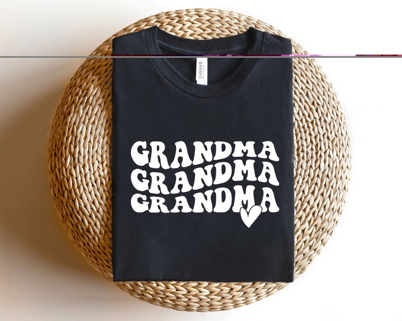 May include: Black t-shirt with white text that reads "Grandma Grandma Grandma" with a small white heart.