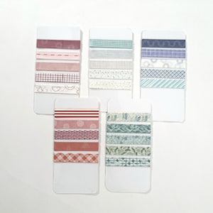 May include: Five cards with different patterned washi tapes. Each card has five different tapes in various colors and patterns, including red, pink, blue, green, and white.
