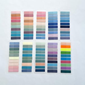 May include: A set of 12 colorful sticky note tabs with different shades of blue, green, pink, purple, and orange. Each tab has 10 individual sticky notes.