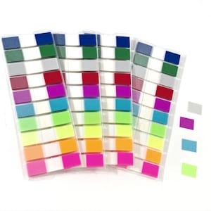 May include: A collection of colorful sticky note flags in a variety of hues, including blue, green, pink, and orange. The flags are arranged in clear plastic dispensers, ideal for marking pages or organizing documents. Additional loose flags are also visible.