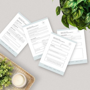 a table topped with papers next to a potted plant