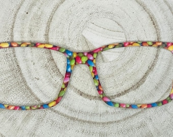 May include: A pair of eyeglasses with a colorful candy-like pattern on the frame.