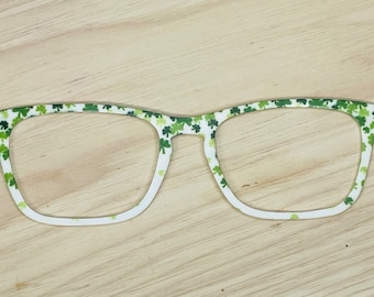 May include: White framed glasses with a green shamrock pattern.