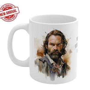 May include: White ceramic mug with a watercolor illustration of a man with a beard and a brown leather strap. The background is a watercolor wash of brown and orange.