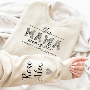 This Mama Wears Her Heart On Her Sleeve Sweatshirt for Mothers Day, Custom Mama Sweatshirt with kids Name on Sleeve, Mother Day Gift for Mom