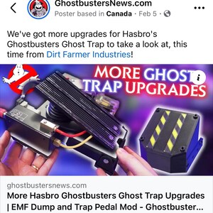 May include: A close-up of a black and yellow Ghostbusters Ghost Trap with a black and white pedal. The trap has a black and yellow striped design and a black base. The text "MORE GHOST TRAP UPGRADES" is displayed in white letters on a blue background.