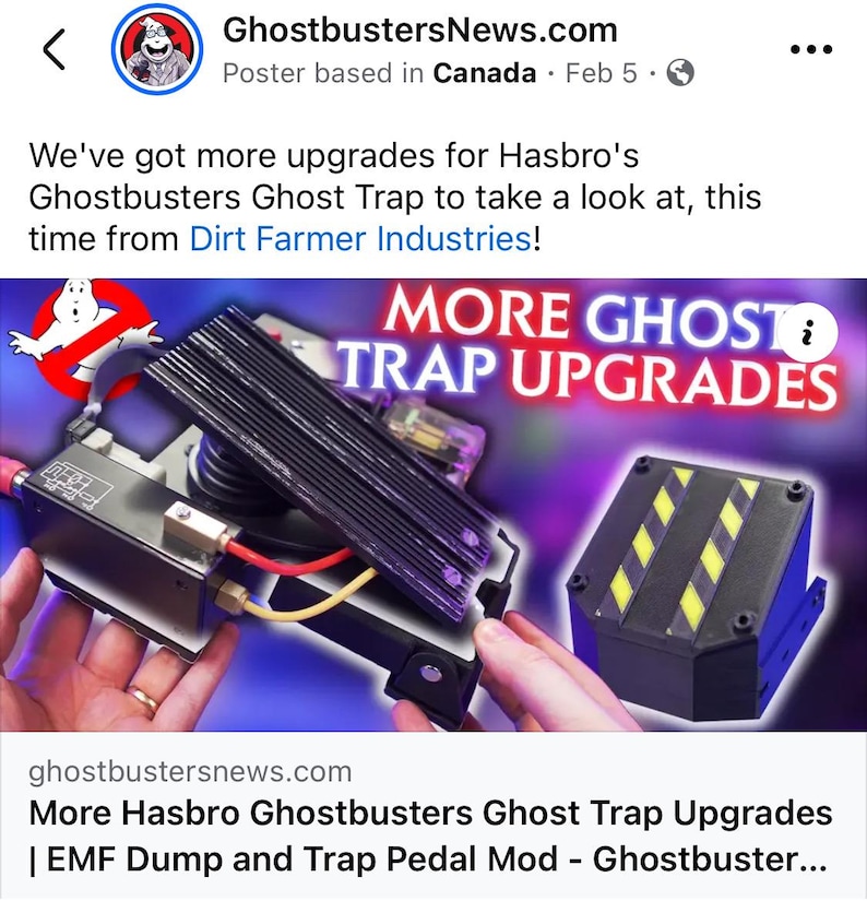 May include: A close-up of a black and yellow Ghostbusters Ghost Trap with a black and white pedal. The trap has a black and yellow striped design and a black base. The text "MORE GHOST TRAP UPGRADES" is displayed in white letters on a blue background.