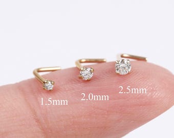 Peut inclure: Trois bijoux de nez en forme de L en or avec des pierres rondes transparentes, étiquetés avec les tailles 1,5 mm, 2,0 mm et 2,5 mm. Chaque bijou présente un sertissage à griffes retenant une pierre étincelante, illustrant la variation de taille.