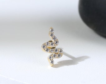Puede incluir: Pendiente de serpiente de oro con piedras de circonita cúbica transparentes.