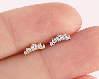 Könnte beinhalten: Zwei kronenförmige Ohrringe mit kleinen, klaren Steinen, einer in Gold und einer in Silber. 14K Massivgold.