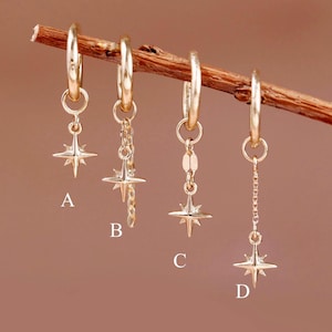 May include: Four gold-toned hoop earrings hanging from a thin wooden twig. Each earring features a four-pointed star charm. Style A has a direct star, B has a short chain, C has a flat link, and D has a longer chain. Each is labeled A, B, C, D.