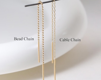 May include: Two gold threader earrings hanging from a thin horizontal wire. The left earring is a bead chain with a straight bar end, labeled Bead Chain. The right earring is a cable chain with a straight bar end, labeled Cable Chain.