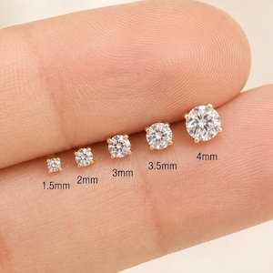 May include: Five gold stud earrings with clear round stones, arranged in increasing size from 1.5mm to 4mm. Each earring is labeled with its specific diameter in millimeters, showing a clear progression in scale for these jewelry pieces.