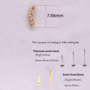 May include: A curved gold earring top with five clear stones measuring 7.56mm. Includes titanium push backs in 20g 0.8mm at 6mm, 8mm, and 10mm lengths, and solid gold backs in 20g 0.85mm at 6mm and 8mm lengths. Text states top is 14K solid gold.