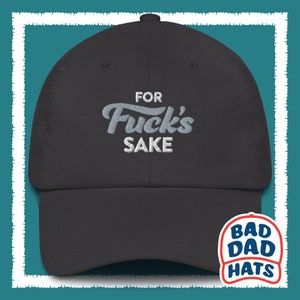 May include: A black baseball cap with white embroidered text that reads "For Fuck's Sake". The cap has a curved brim and a white logo on the back that reads "Bad Dad Hats".