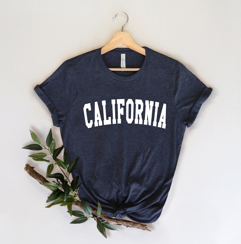 K&ouml;nnte beinhalten: Ein dunkelblaues T-Shirt mit dem Wort "CALIFORNIA" in wei&szlig; auf der Vorderseite.