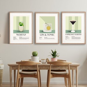 May include: Three framed art prints featuring cocktail illustrations. The prints showcase a Mojito, Gin & Tonic, and Espresso Martini, each with a recipe. The artwork has a light green and beige color scheme, with wooden frames.