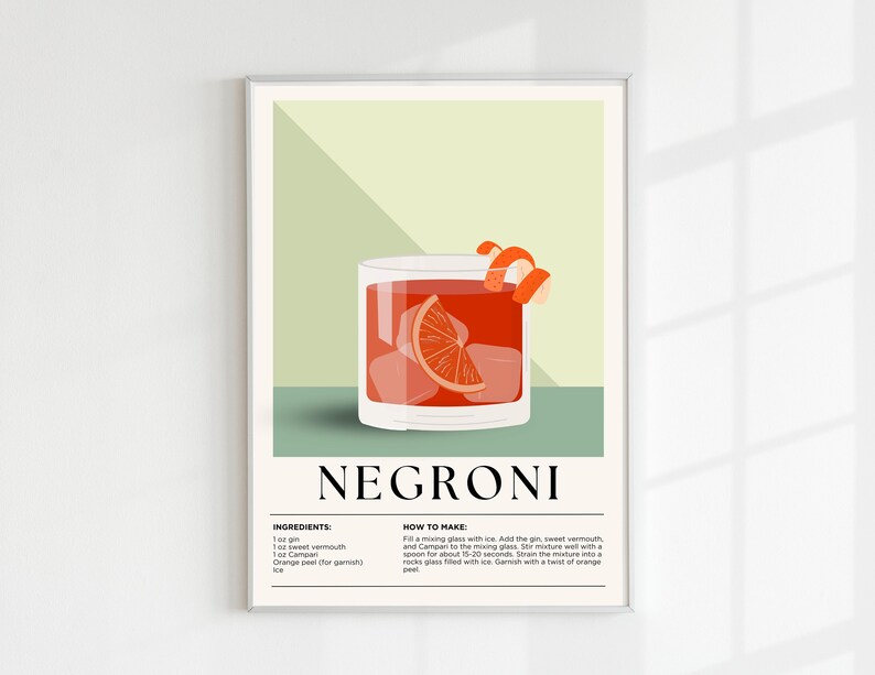 May include: A framed art print featuring a Negroni cocktail illustration. The image shows a glass filled with ice, a red drink, and an orange slice. The word "NEGRONI" is at the bottom, with the ingredients and instructions listed below.