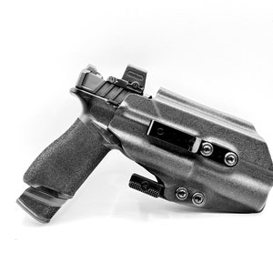 May include: A black handgun with a black holster and a red dot sight. The holster has a belt clip and multiple screws.